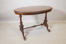 A Victorian burr walnut stretcher table, the oval top with carved edge, raised on turned and
