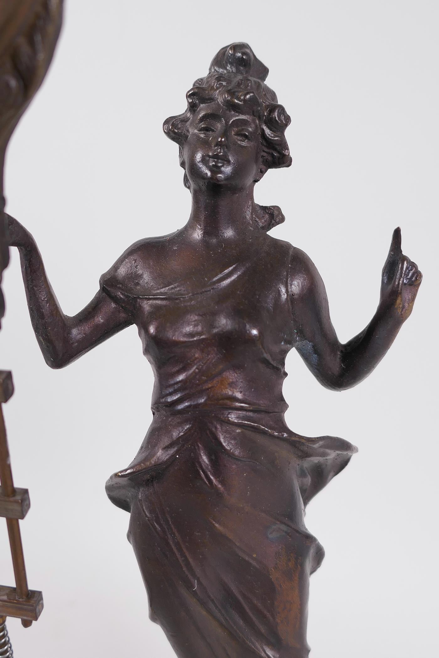 A bronze mystery clock cast as an Art Nouveau style lady with the clock raised on one arm, 13" high - Image 2 of 4