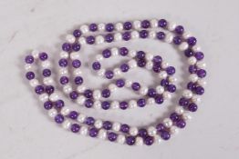 A string of pearl and amethyst coloured beads, 47" long