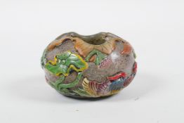 A Peking glass bird feeder with raised enamel decoration of waterfowl in a lotus pond, 2½" diameter