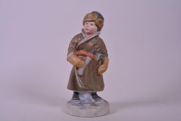 A mid-century Soviet Russian Pesochnoe bisque porcelain figure of a young Cossack boy with an axe,