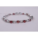A silver bracelet set with alternating cubic zirconia and garnets, 6" long