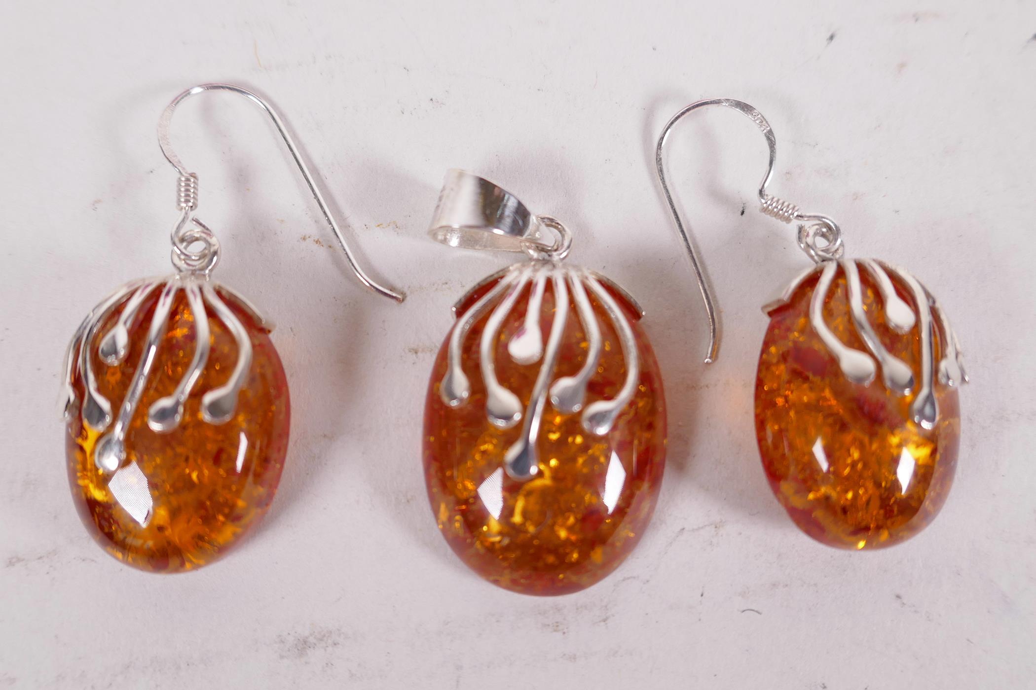 A silver and faux amber suite of earrings and pendant drop (3)