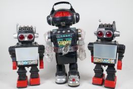 Three 1980s battery operated robots, largest 16" high