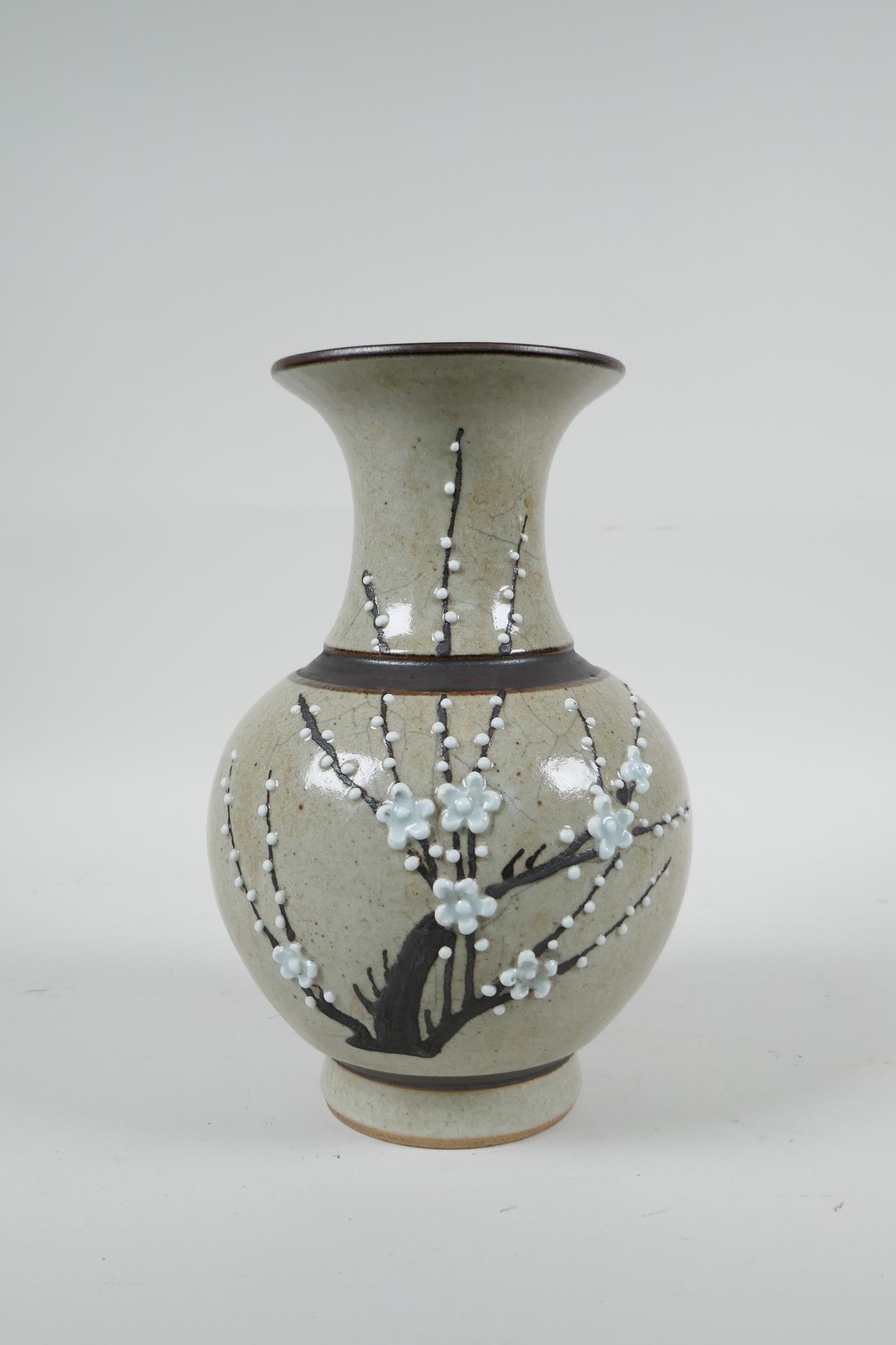 A Chinese beige ground pottery vase with bronze style bands and prunus blossom decoration, 8" high