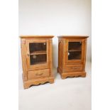 A pair of pine side cabinets with glazed door and single drawer raised on a bracket base, 21½" x