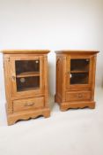 A pair of pine side cabinets with glazed door and single drawer raised on a bracket base, 21½" x