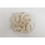 A Chinese white jade pendant carved in the form of entwined dragons, 2" x 2"