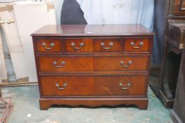 A mahogany chest of three over two long drawers, with crossbanded top, raised on a shaped plinth,