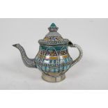 A Moorish ceramic and white metal teapot encased with wire metal and painted with a traditional