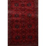 A 100% wool pile terracotta ground rug with an Afghan design, 47" x 67"