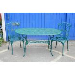 A cast aluminium oval top garden table on shaped legs with undertier together with a pair of