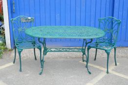 A cast aluminium oval top garden table on shaped legs with undertier together with a pair of