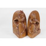 A pair of Balinese hardwood bookends carved as male and female figures, 8" high