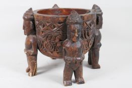 An ethnic carved wood bowl supported by four figures, 7" diameter, 7½" high