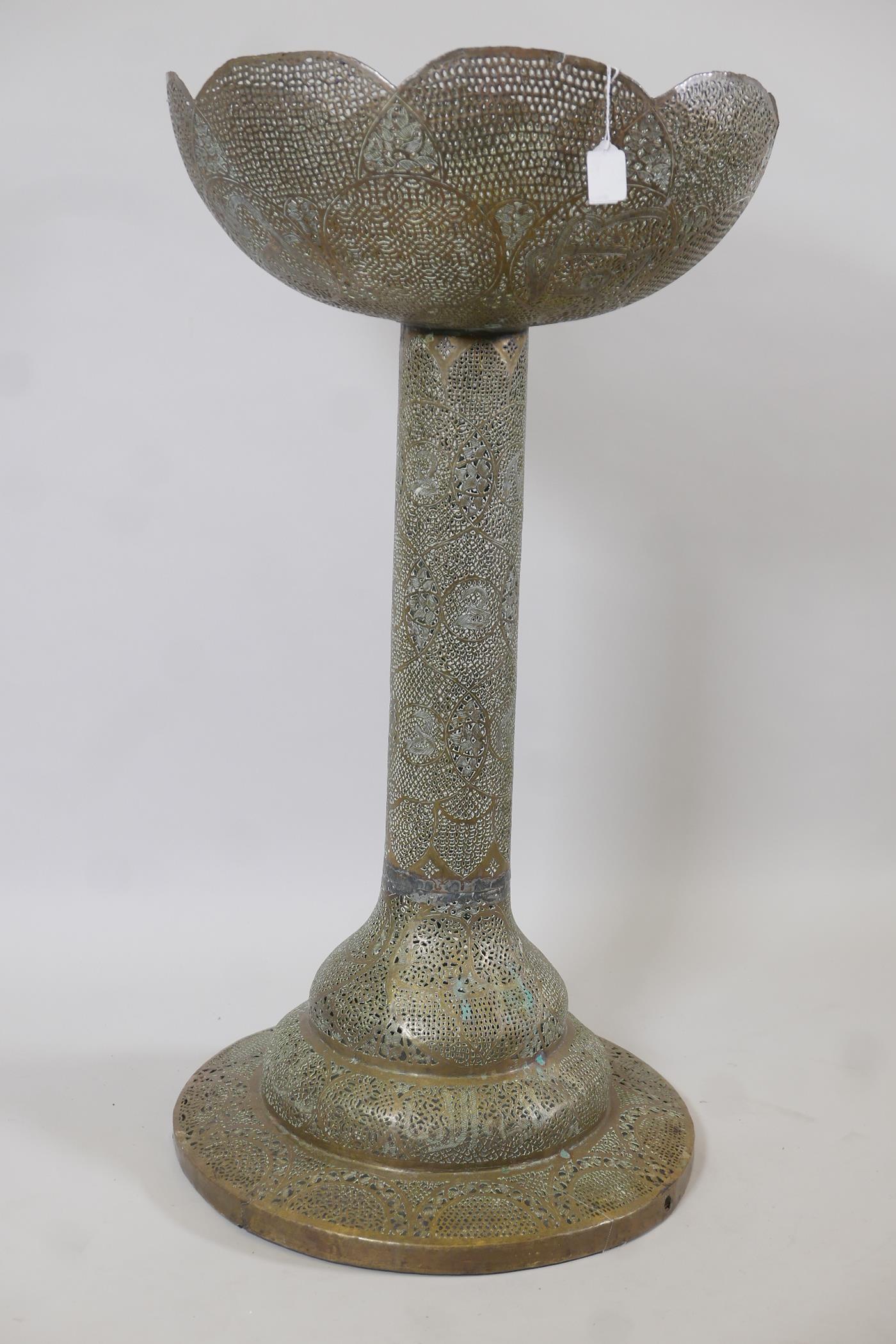 An Indo-Persian pierced brass pedestal with basket top decorated with script and flowers, 39" high
