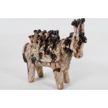 An unusual studio pottery figure of an Indian cow with elaborate saddle, part treacle glazed, 10"