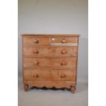 A Victorian stripped pine chest of two over three drawers, with wood handles and shaped apron,