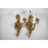 A pair of gilt metal Rococo style twin branch electric wall sconces, 16" high