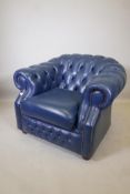 A blue leather buttoned club chair in the Chesterfield style, 31" high x 40" wide