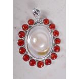 An oval mother of pearl and coral set pendant, 2½" long