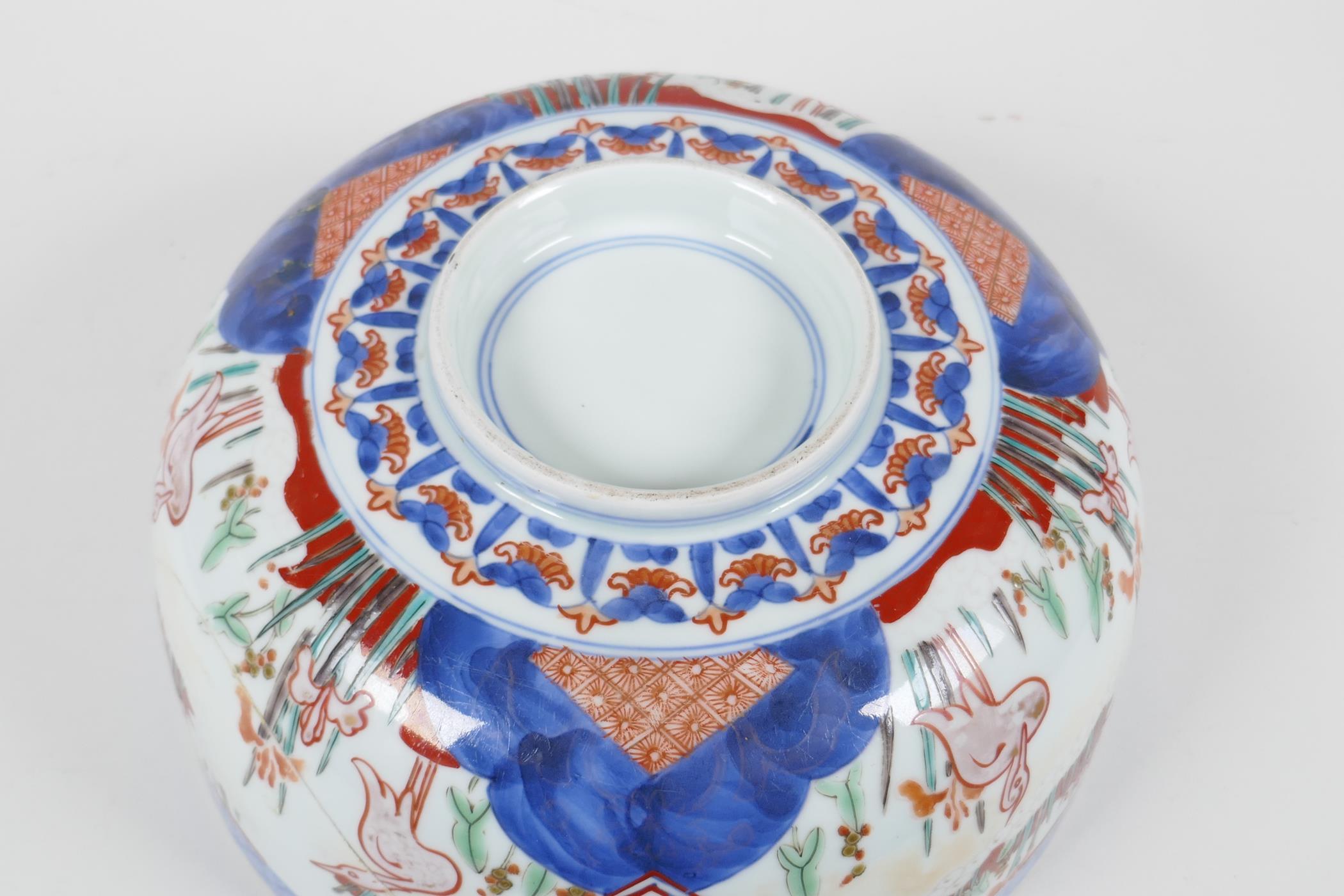 A C19th Japanese Imari porcelain bowl painted with herons amongst the reeds, in traditional colours, - Image 5 of 6