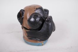 A cast metal inkwell in the form of a dog's head, cold painted in black and brown with a blue