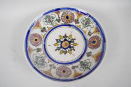 A C19th Persian pottery shallow bowl painted with flowers, 10" diameter