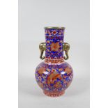 A Chinese porcelain two handled vase with red and blue phoenix and floral decoration, with gilt