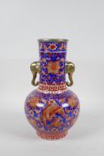 A Chinese porcelain two handled vase with red and blue phoenix and floral decoration, with gilt