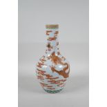 A Chinese polychrome porcelain bottle vase decorated with an iron red and gilt dragon chasing the
