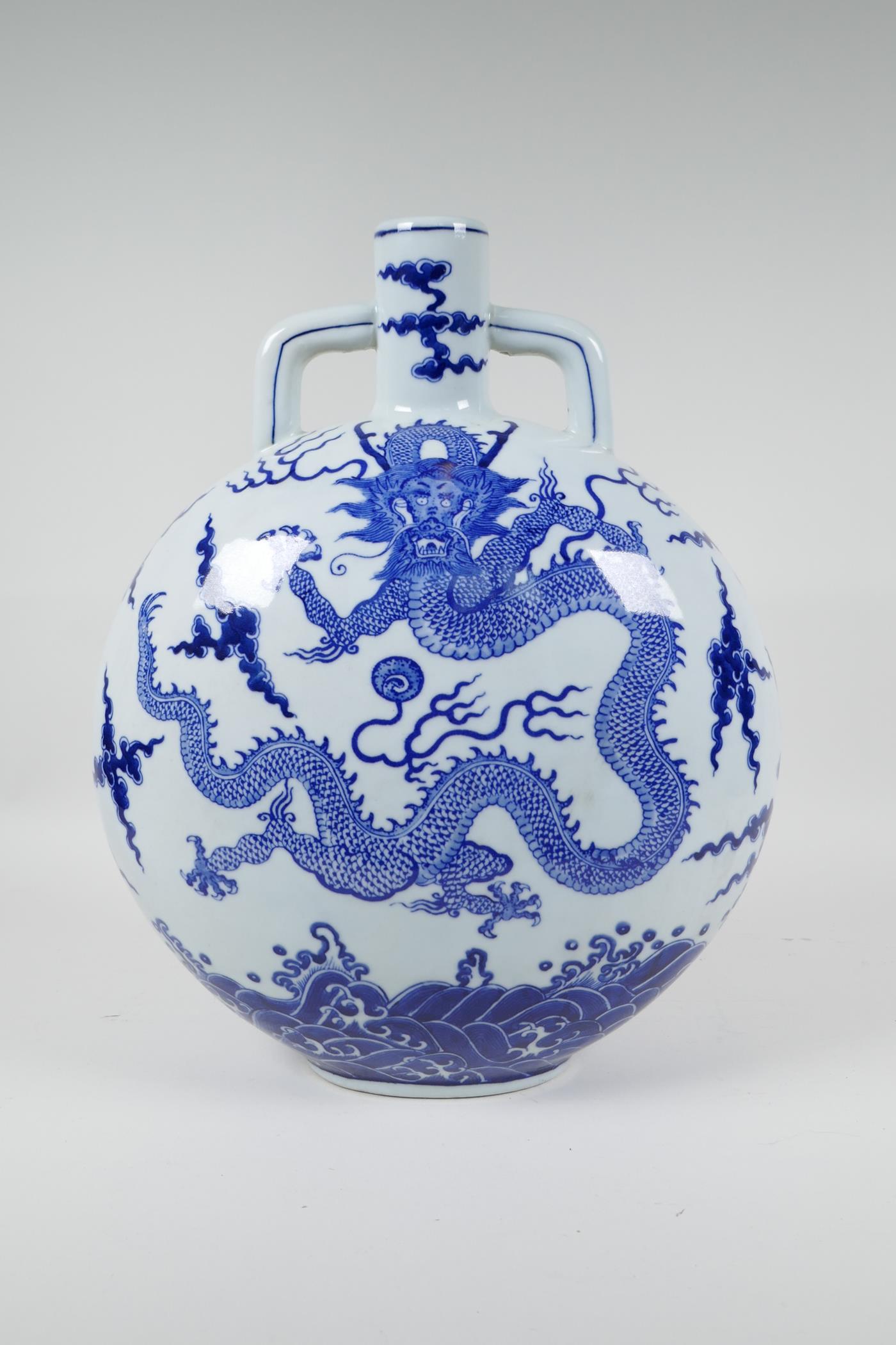 A Chinese blue and white porcelain moon flask decorated with a dragon chasing the flaming pearl,