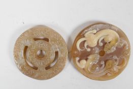 A Chinese carved faux horn pi disc pendant with twin kylin decoration, and a hardstone pi disc