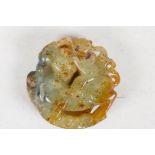 A Chinese carved jade pendant carved as a horse and rider, 2" diameter