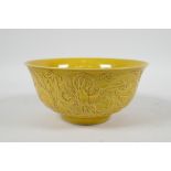A Chinese yellow ground porcelain rice bowl with raised dragon decoration, 6 character mark to base,