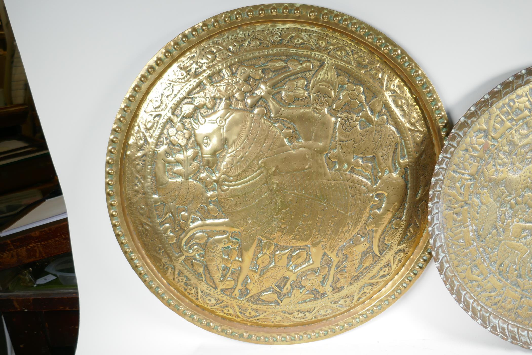 A Persian brass charger embossed with a figure on horseback surrounded by animals and birds, 24" - Image 4 of 4