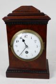 A C19th walnut cased mantel clock of architectural form with timepiece movement, white enamel dial