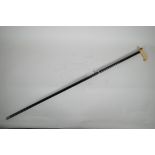 A Victorian dandy's cane, with ebonised shaft and bone handle with pinchbeck mounts inset with