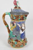 A C19th Minton majolica tower jug with pewter rimmed lid decorated with dancing figures, the lid