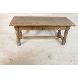 A bleached oak coffee table, with single drawer raised on turned supports united by an 'H'