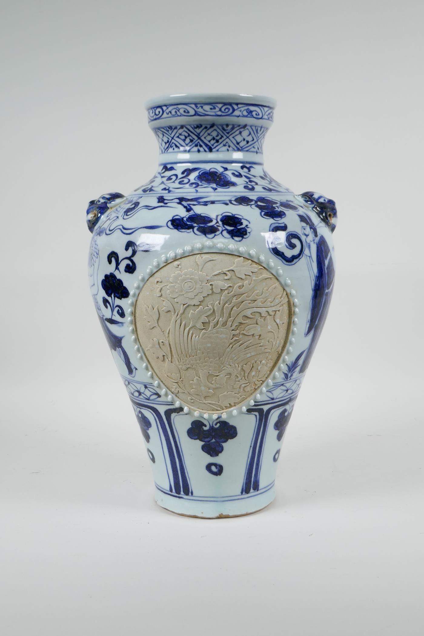 A Chinese blue and white porcelain vase with two lion mask handles, chased decorative panels