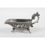 A Chinese white metal libation cup with stylised dragon decoration and tripod feet, mark to base,
