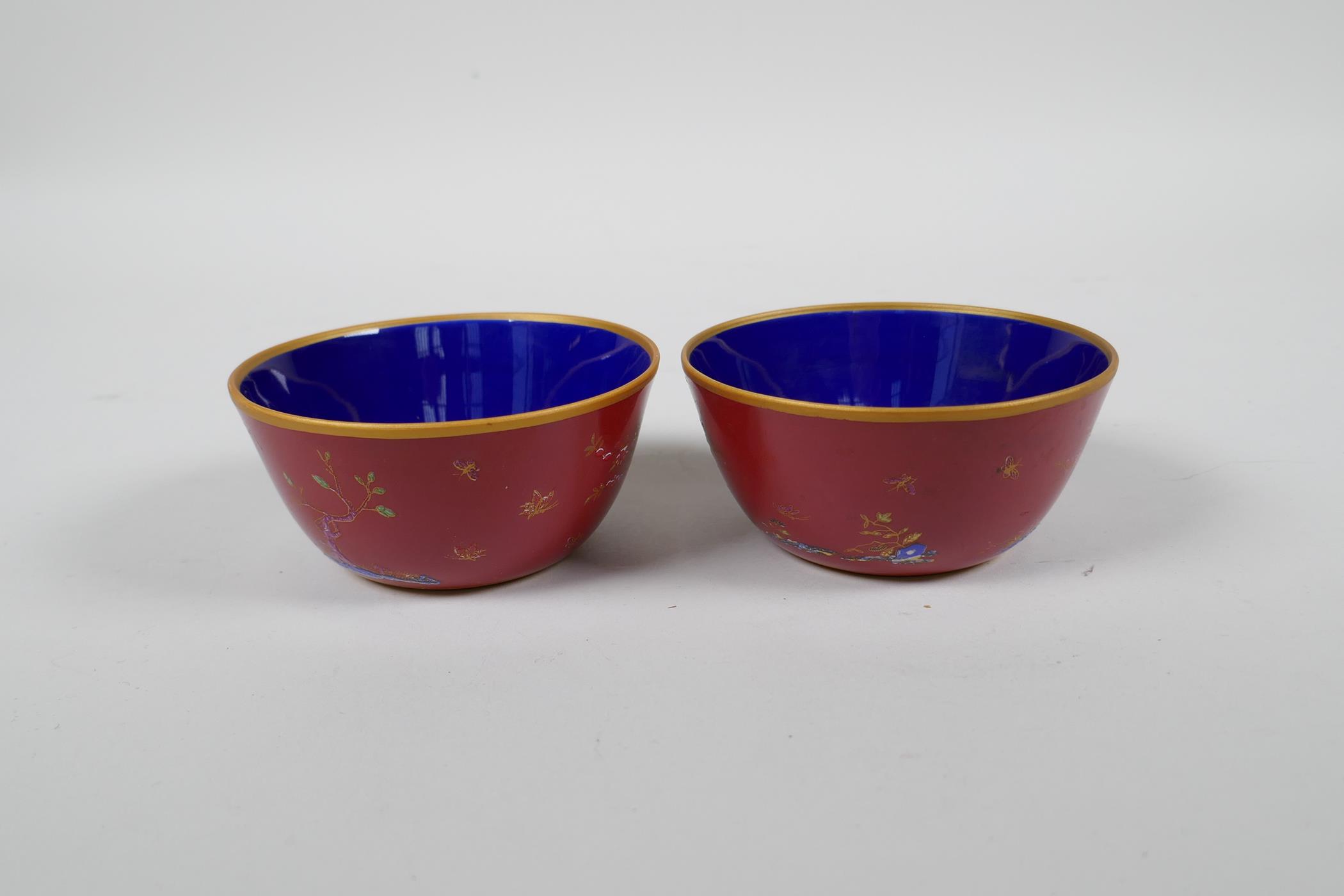 A pair of Chinese red ground porcelain tea bowls with polychrome decoration of flowers, foliage - Image 3 of 5