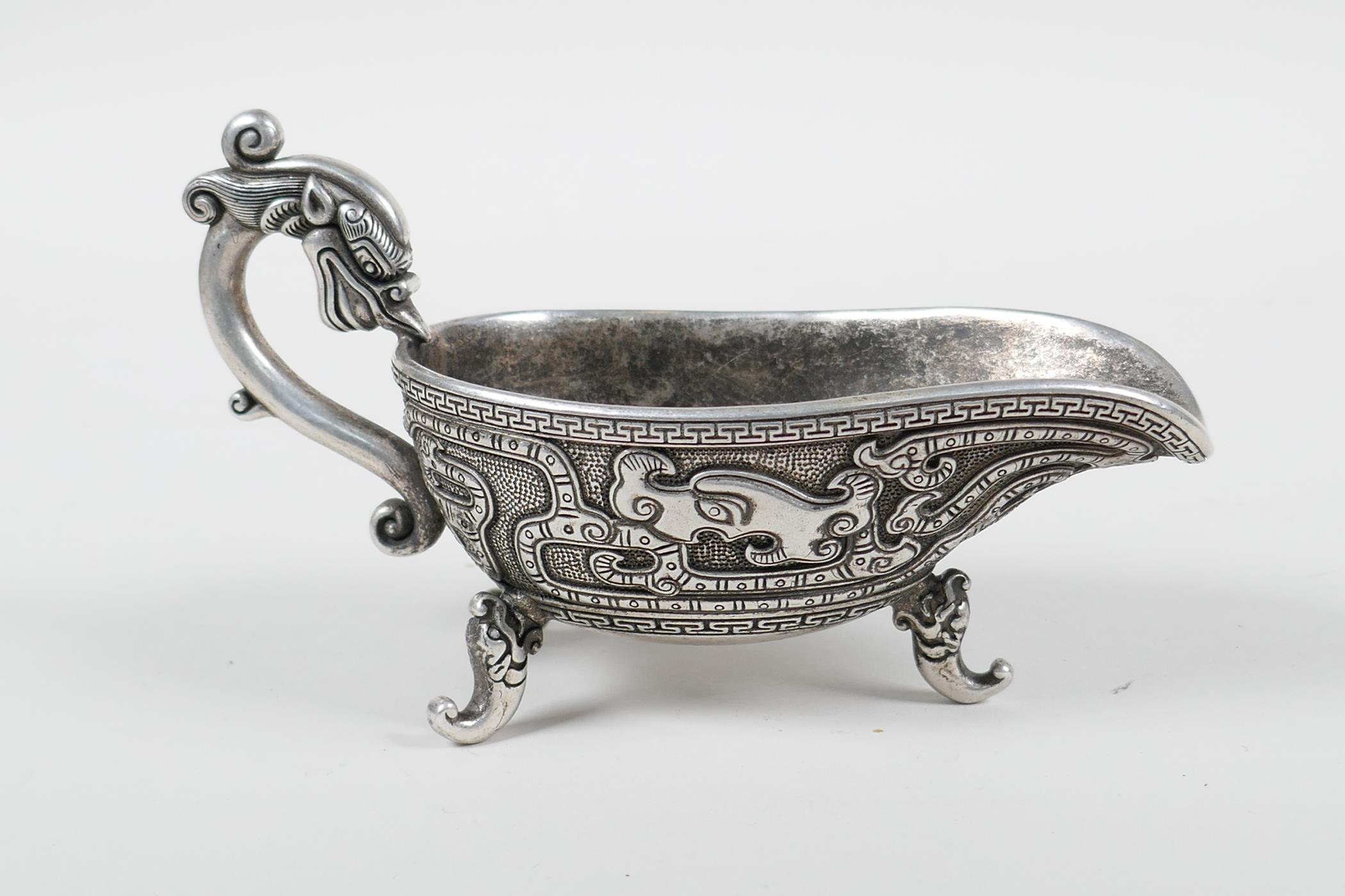 A Chinese white metal libation cup with stylised dragon decoration and tripod feet, mark to base, - Image 2 of 3