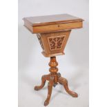 A Victorian walnut workbox with lift up top and pierced basket, raised on a turned column and carved