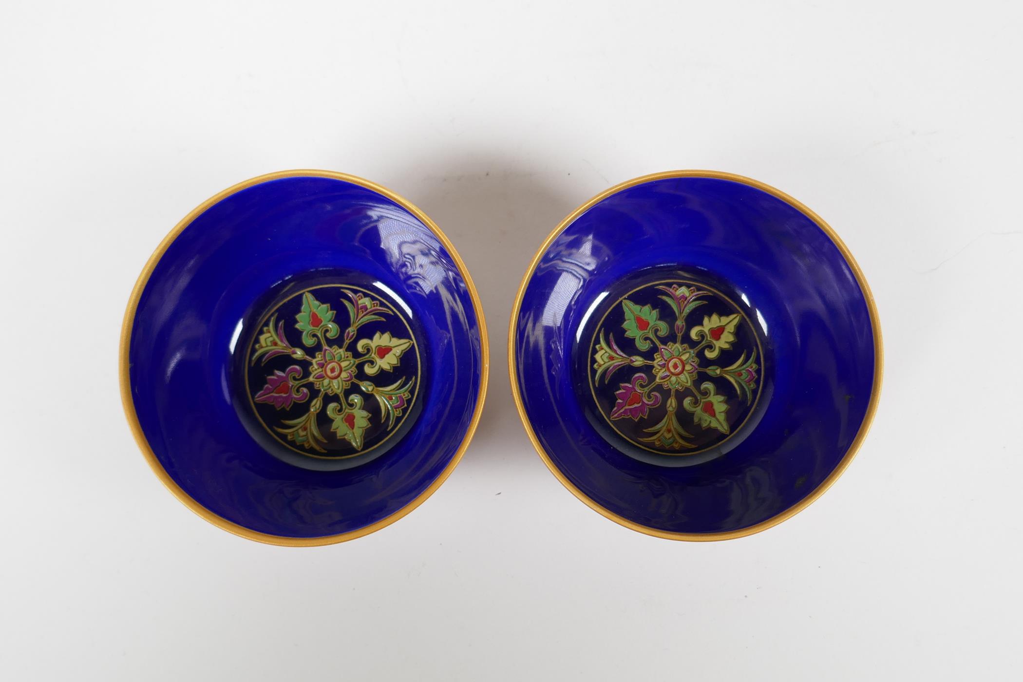 A pair of Chinese red ground porcelain tea bowls with polychrome decoration of flowers, foliage - Image 4 of 5