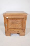 A walnut Art Deco side cabinet with a carved panel door and ribbed feet, 25½" x 16", 28" high