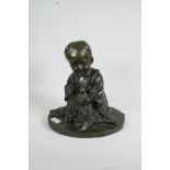 A patinated bronze figure of an Oriental child holding a doll, 12" high