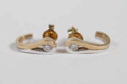 A pair of mixed gold half loop diamond earrings