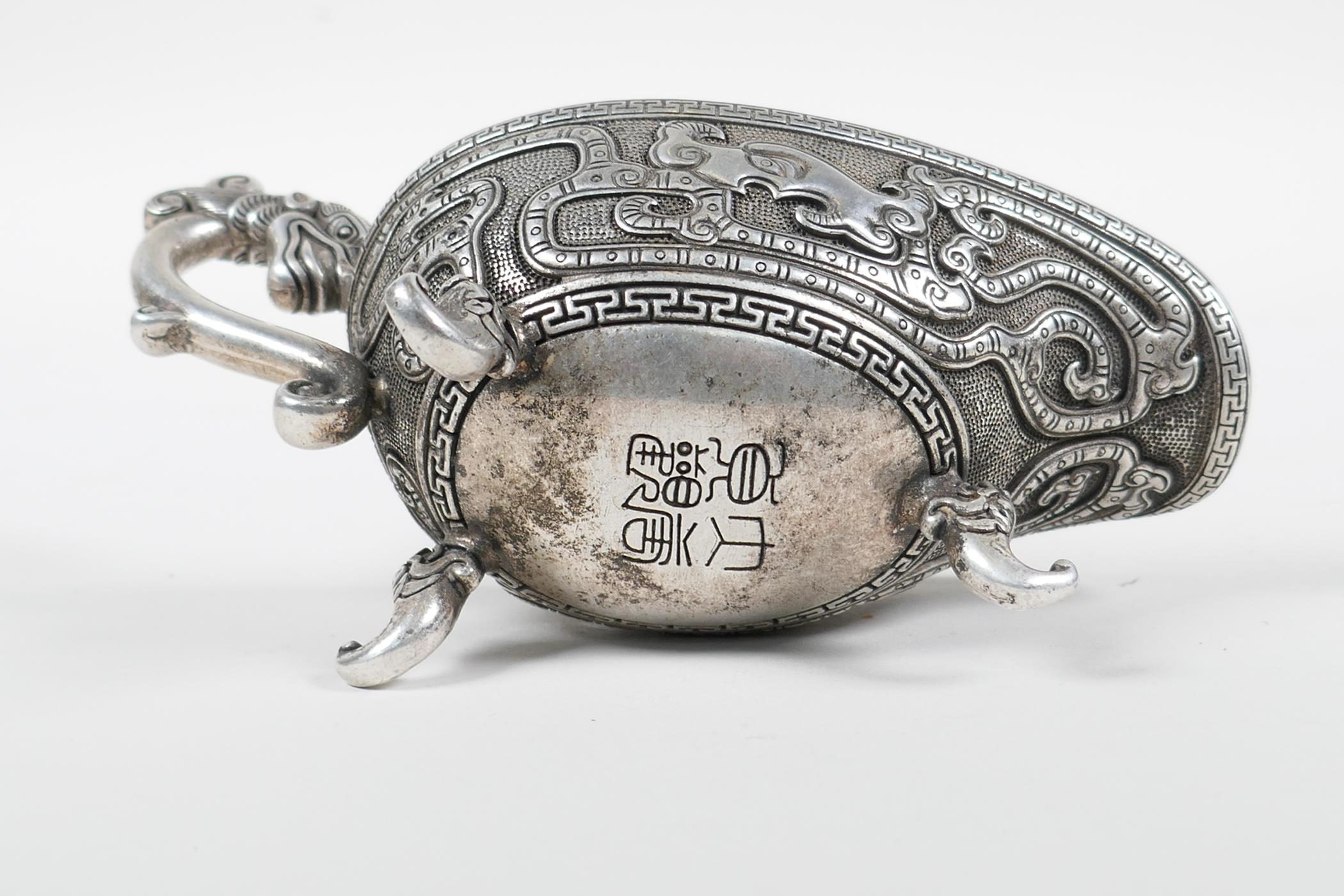 A Chinese white metal libation cup with stylised dragon decoration and tripod feet, mark to base, - Image 3 of 3